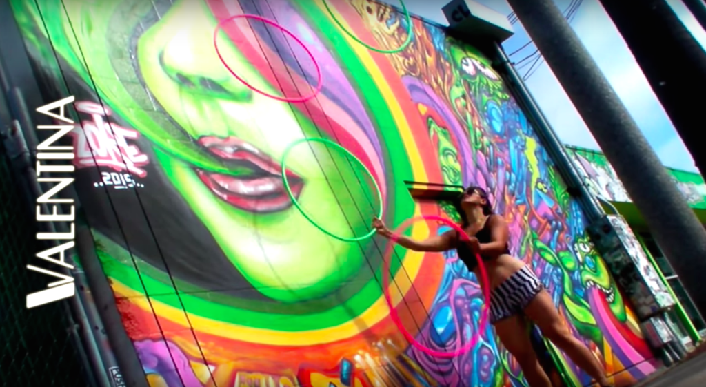 Lady Juggling Hoops In Front of Graffiti Wall